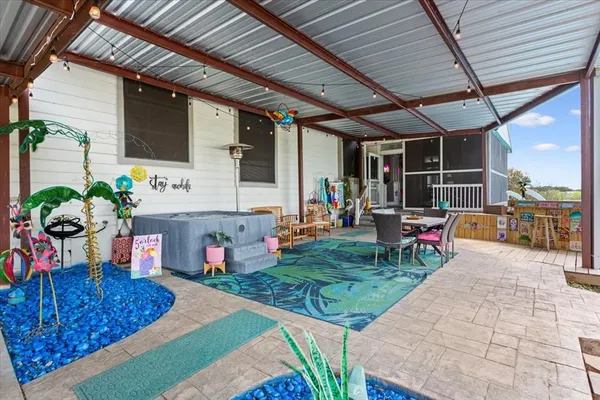 a living room with patio furniture and a flat screen tv