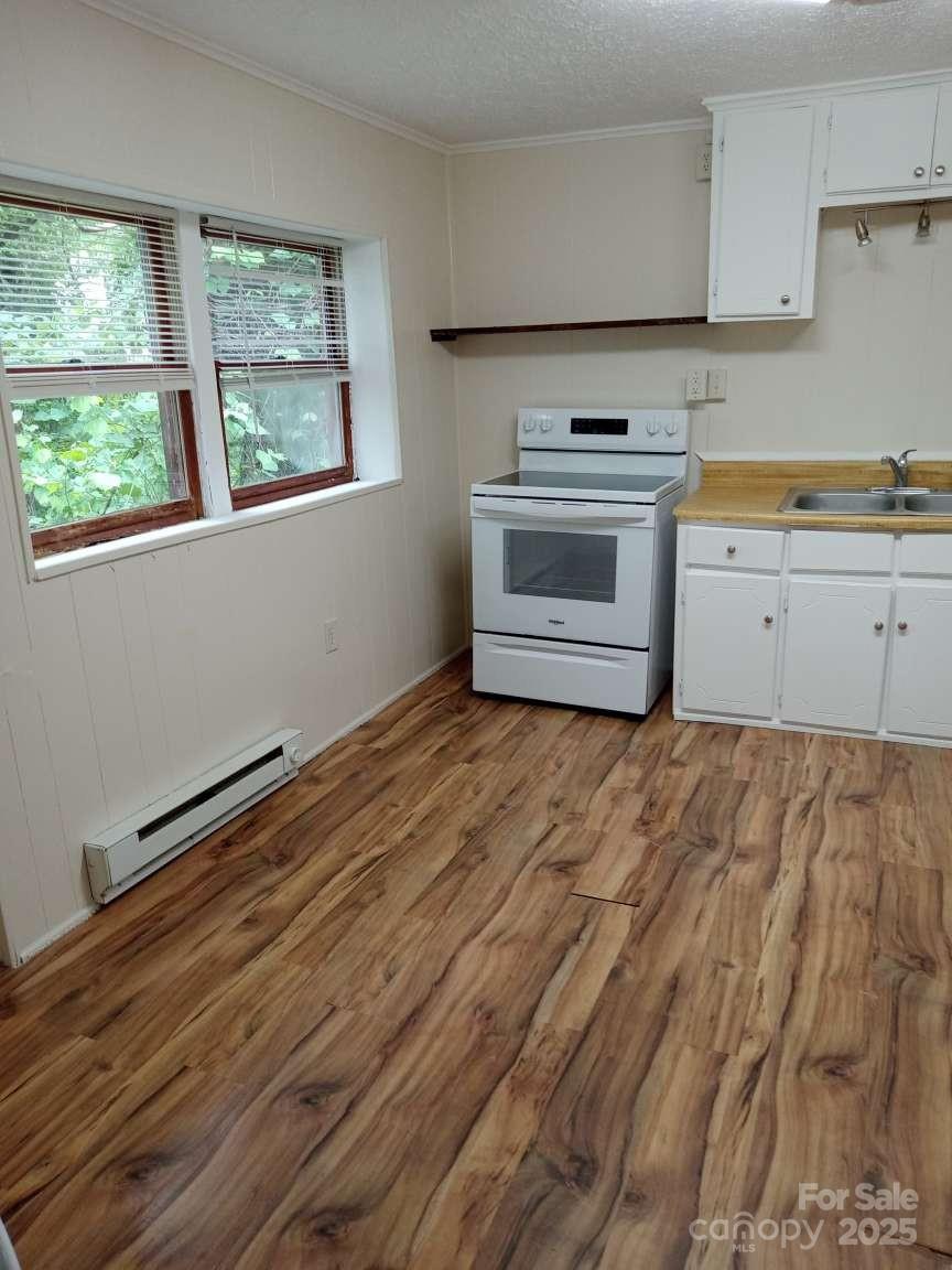381 North Cleghorn Street Rutherfordton, NC 28139 - Photo 12 of 18 a kitchen with a stove and a white wooden cabinets