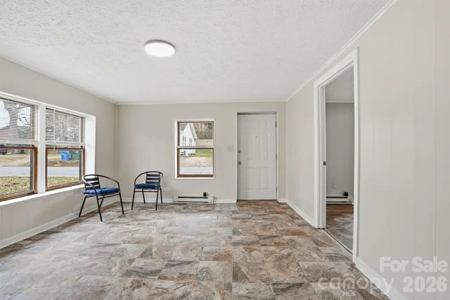 a view of an empty room with window and closet area
