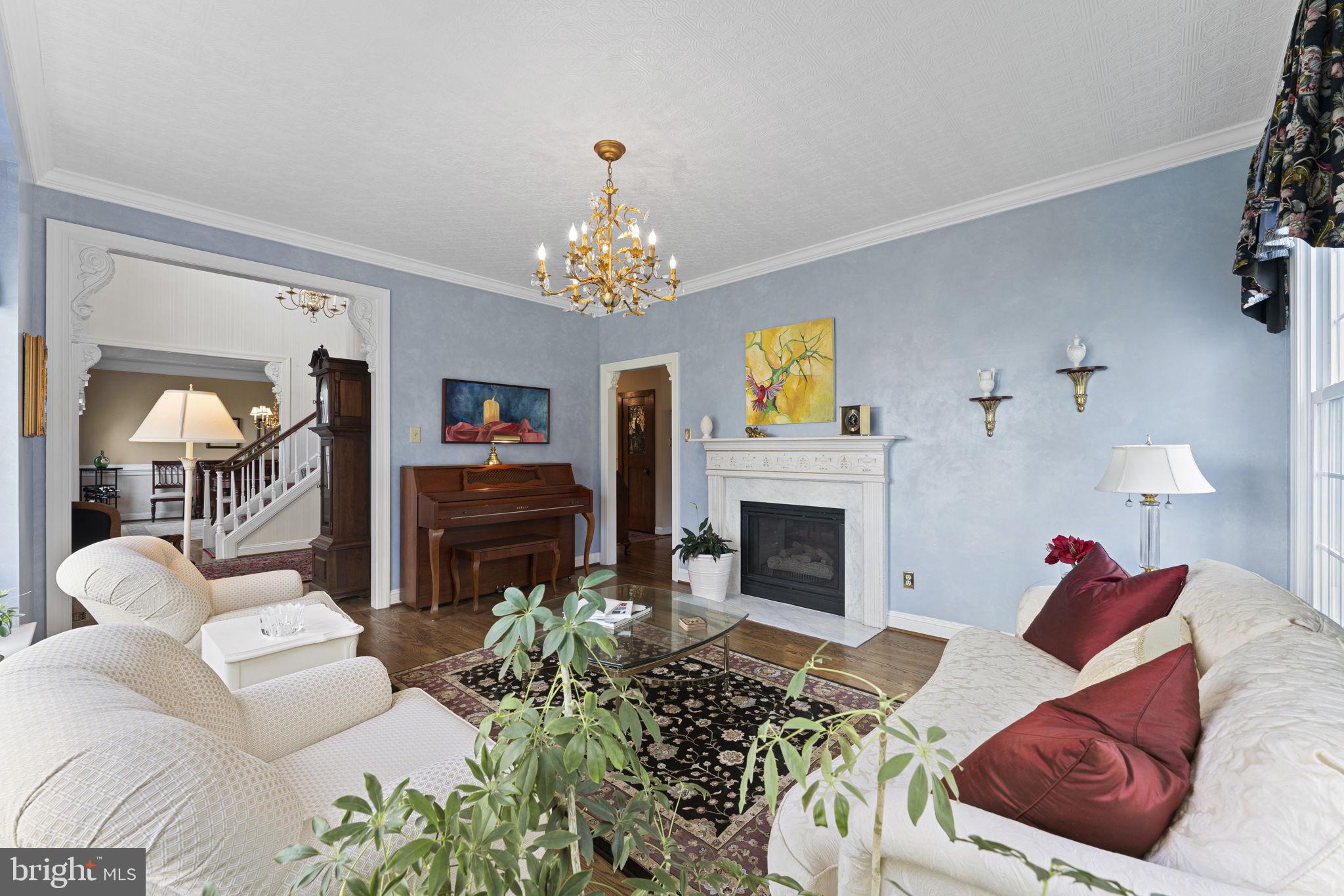 103 Carters Grove, Unit A3 Malvern, PA 19355 - Photo 15 of 41 a living room with furniture a fireplace and a chandelier