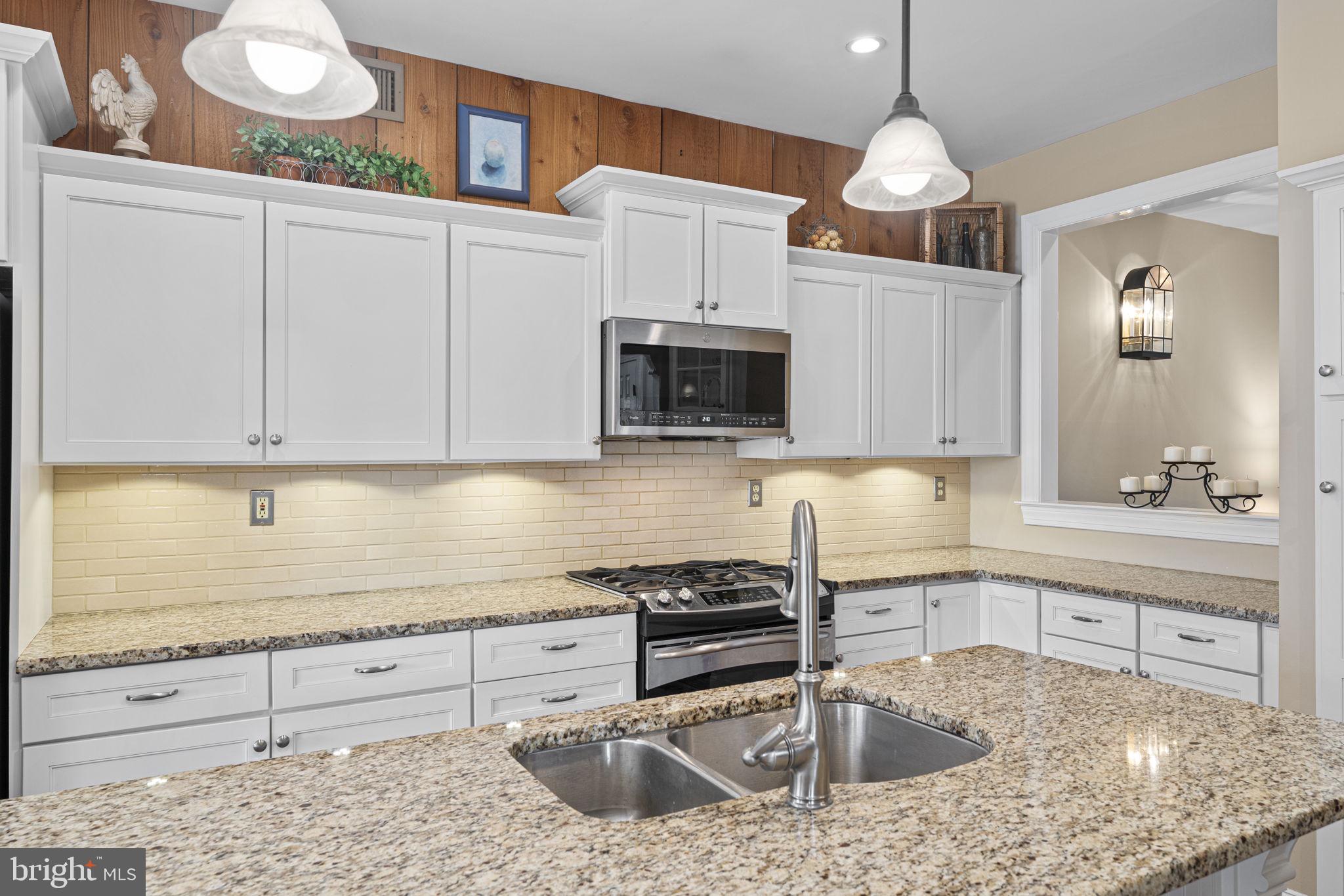 103 Carters Grove, Unit A3 Malvern, PA 19355 - Photo 20 of 41 a kitchen with granite countertop a sink a stove and cabinets