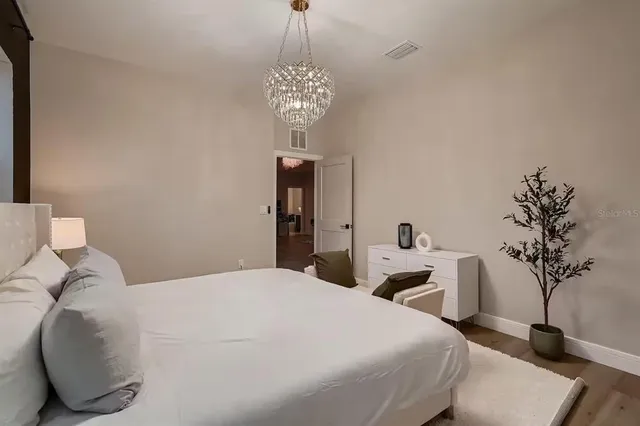 a bedroom with a bed and a chandelier