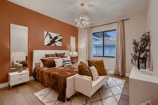 a spacious bedroom with a bed and a chandelier