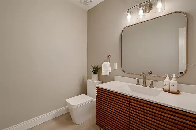 a bathroom with a sink a toilet and mirror