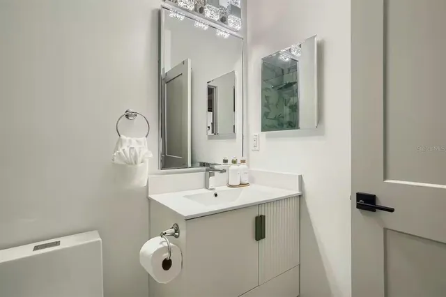 a bathroom with a sink mirror and vanity