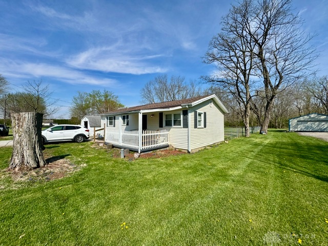 This charming home features a lovely front porch and a spacious yard.