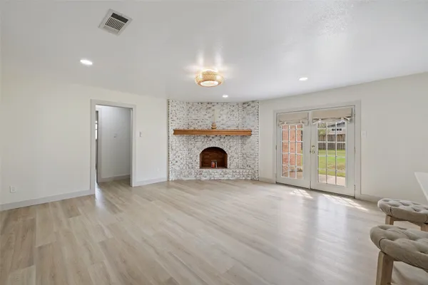 a view of kitchen and empty room with wooden floor