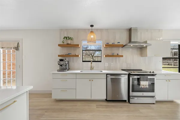 a kitchen with cabinets a sink and chairs