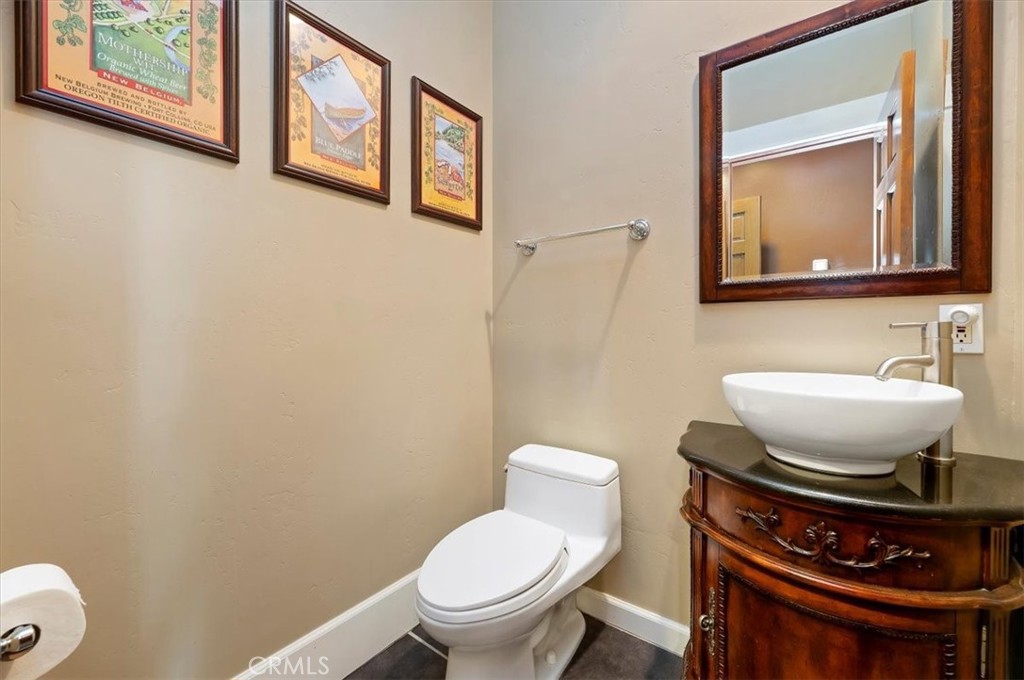 16420 Rocky Glen Road Perris, CA 92570 - Photo 25 of 74 a bathroom with a toilet a sink and a mirror