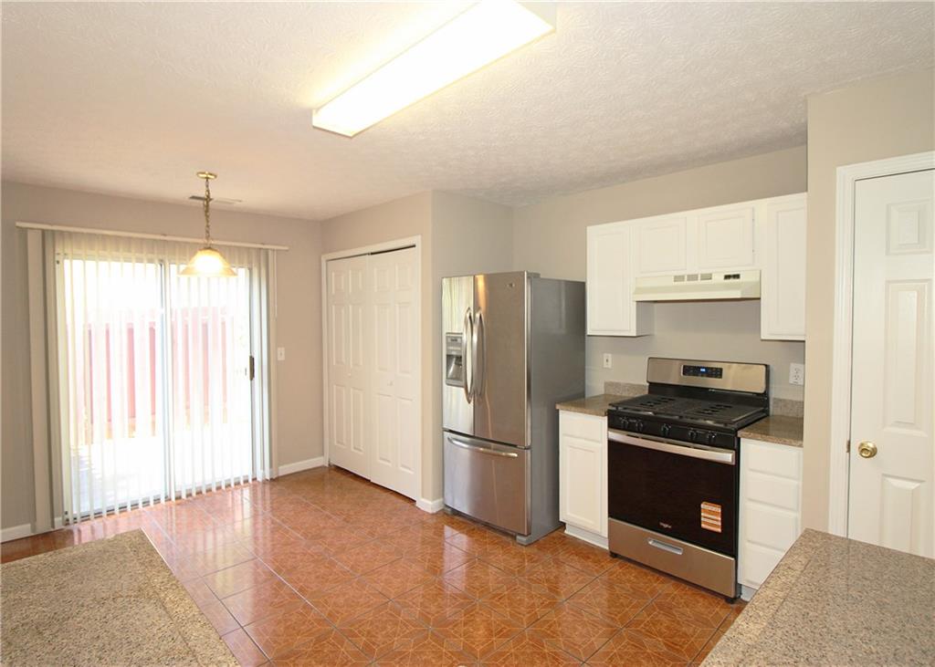 1334 Ambercrest Way Austell, GA 30168 - Photo 8 of 20 a kitchen with granite countertop a refrigerator and a stove top oven