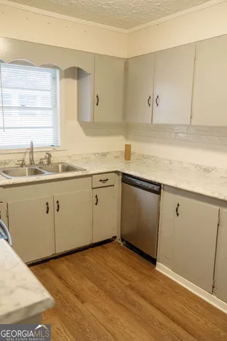 a kitchen with a sink cabinets appliances and a window