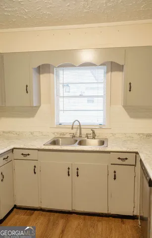 a kitchen with granite countertop white cabinets and a sink