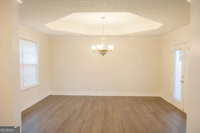 a view of a room with wooden floor and white walls