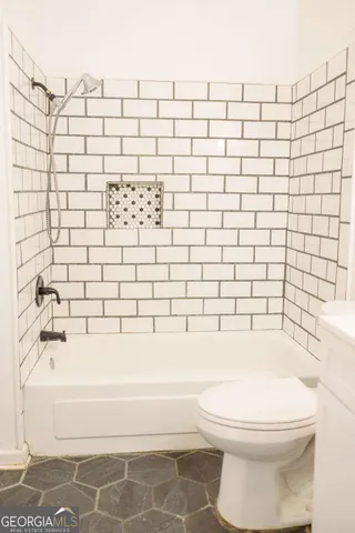 a bathroom with a white toilet and a bathtub