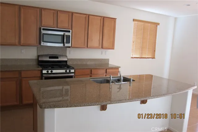 a kitchen with kitchen island a sink a stove and microwave