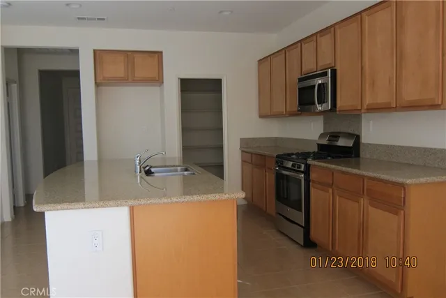 a kitchen with stainless steel appliances granite countertop a sink stove and microwave