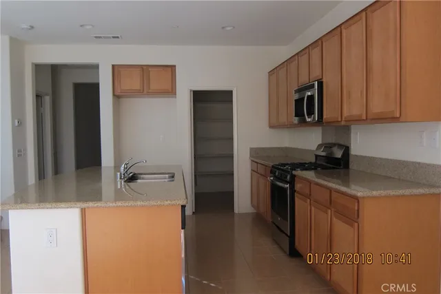 a kitchen with stainless steel appliances granite countertop a refrigerator and a stove top oven