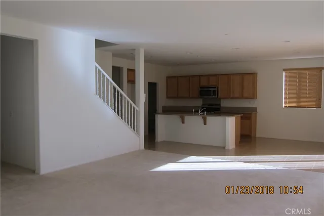 a view of a livingroom with wooden floor and a hallway