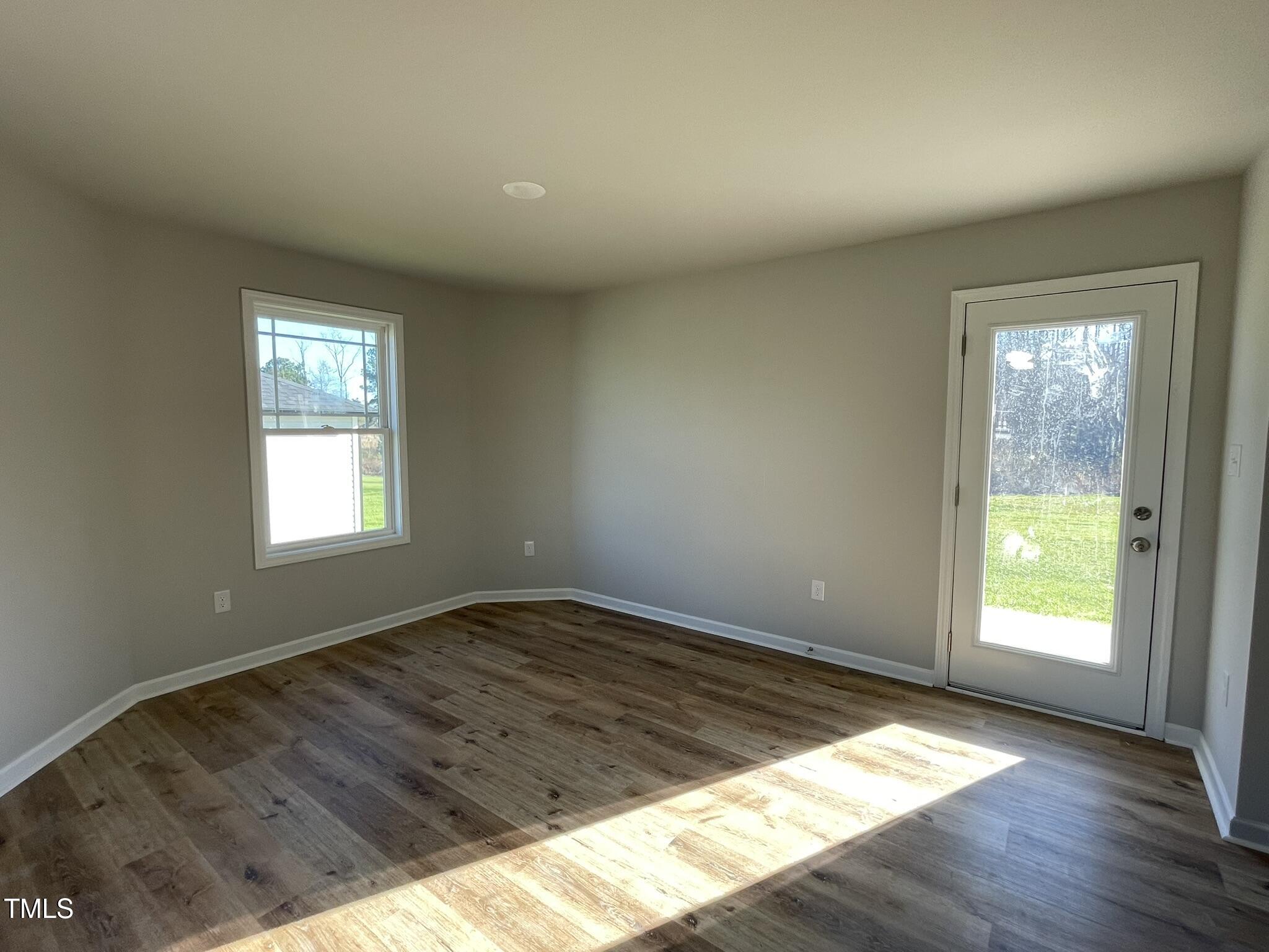 42 Heatherglenn Circle Princeton, NC 27569 - Photo 4 of 15 an empty room with wooden floor and windows