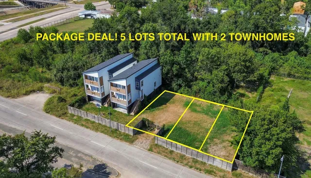 a view of a house with a yard plants and large tree