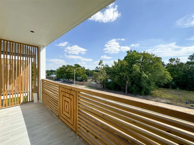 a view of a hallway with wooden floor and windows