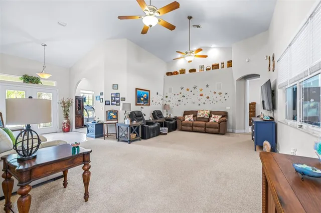 a kitchen with stainless steel appliances kitchen island granite countertop a refrigerator a stove top oven a sink a dining table and chairs with wooden floor