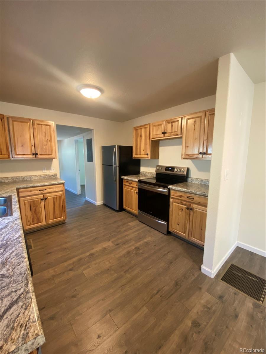 613 Lake Street Rangely, CO 81648 - Photo 5 of 12 a kitchen with stainless steel appliances granite countertop a stove a sink and a refrigerator