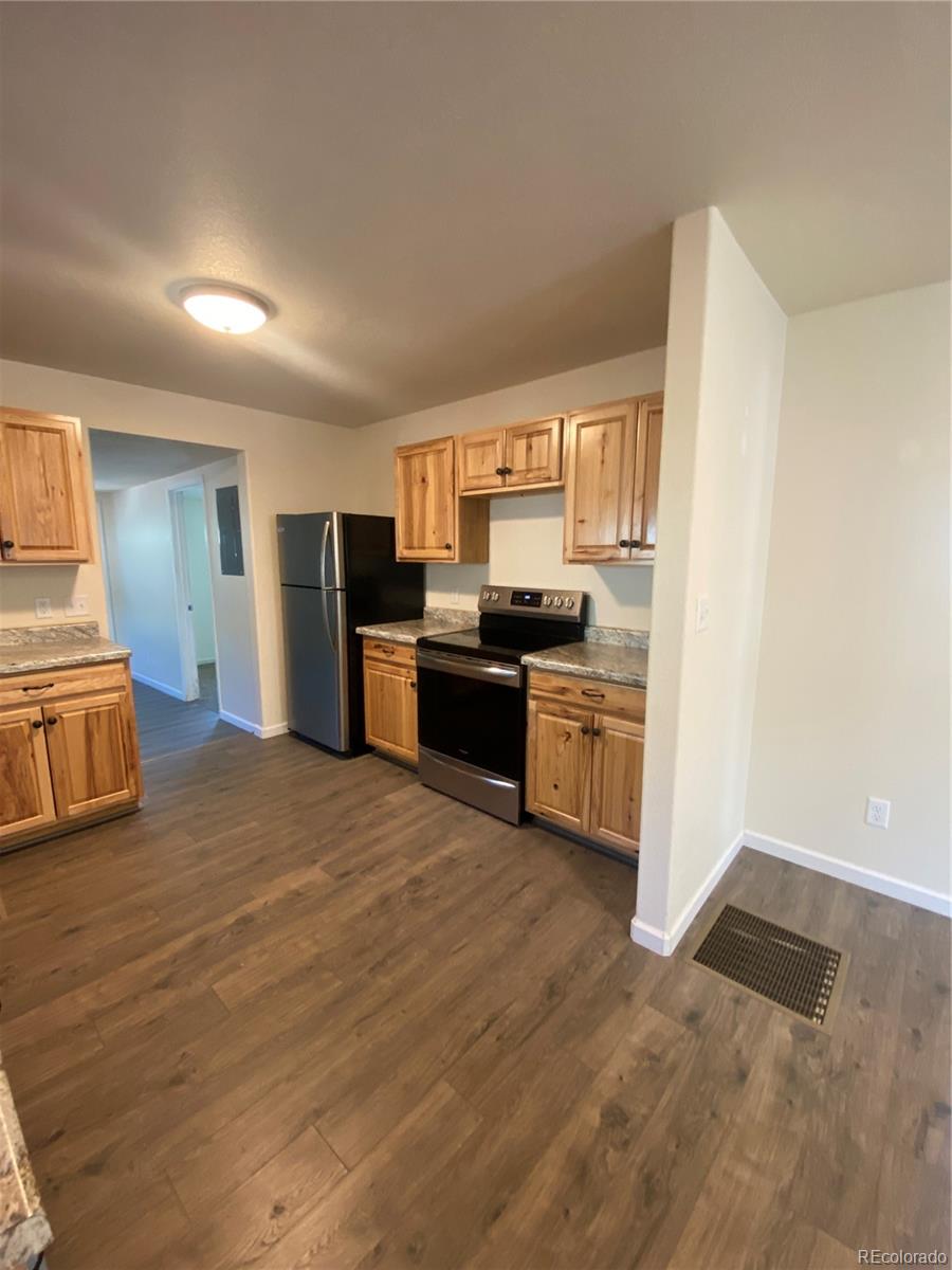 613 Lake Street Rangely, CO 81648 - Photo 6 of 12 a kitchen with stainless steel appliances a stove a refrigerator a sink a oven with wooden floor and cabinets