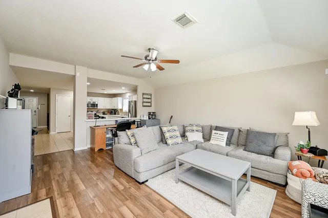 a living room with furniture and a wooden floor