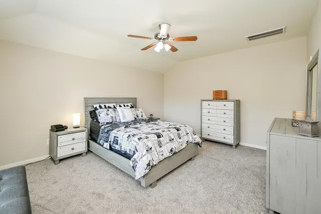 a bedroom with a bed and a ceiling fan