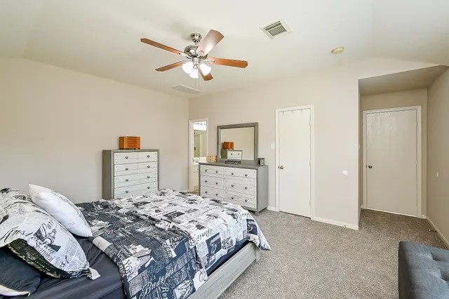 a bedroom with a large bed and a chandelier