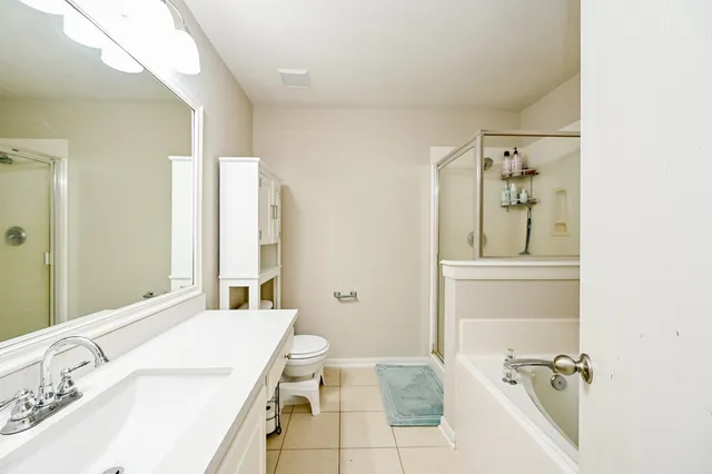 a bathroom with a granite countertop sink a toilet and shower