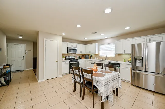a kitchen with stainless steel appliances kitchen island granite countertop a refrigerator and cabinets