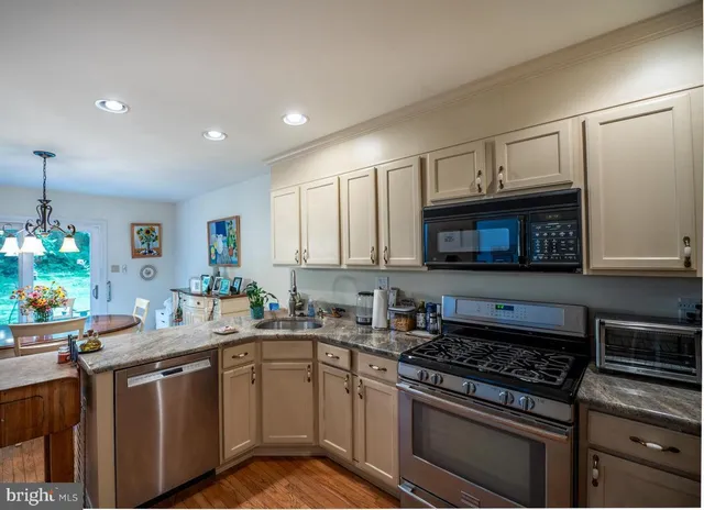 a kitchen with stainless steel appliances a sink stove and cabinets