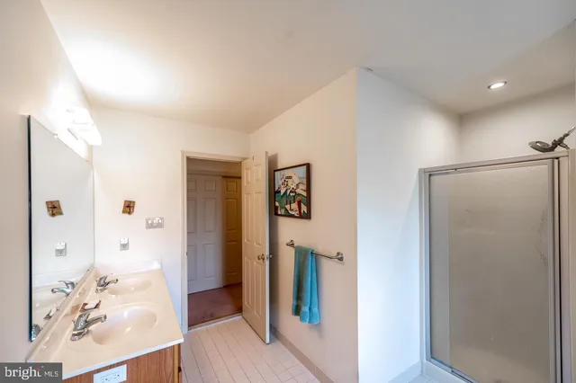 a view of a hallway with bathroom and wooden floor