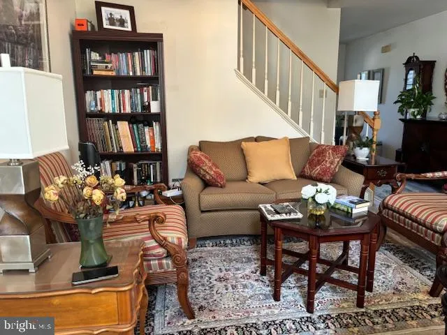 a living room with furniture and a book shelf