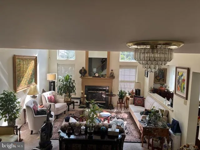 a living room filled with furniture a fireplace and a chandelier