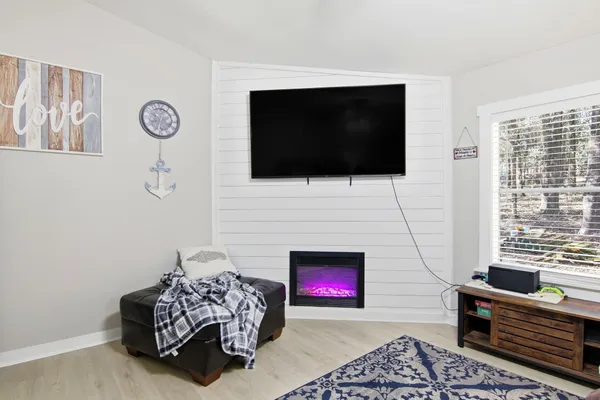 a living room with furniture a flat screen tv and a fireplace