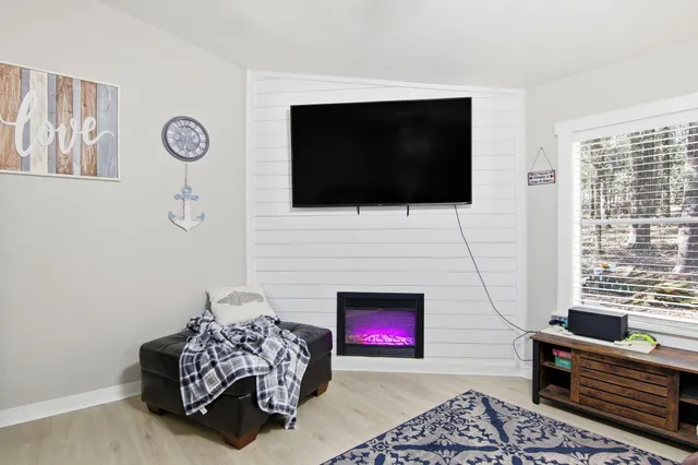 a living room with furniture a flat screen tv and a fireplace
