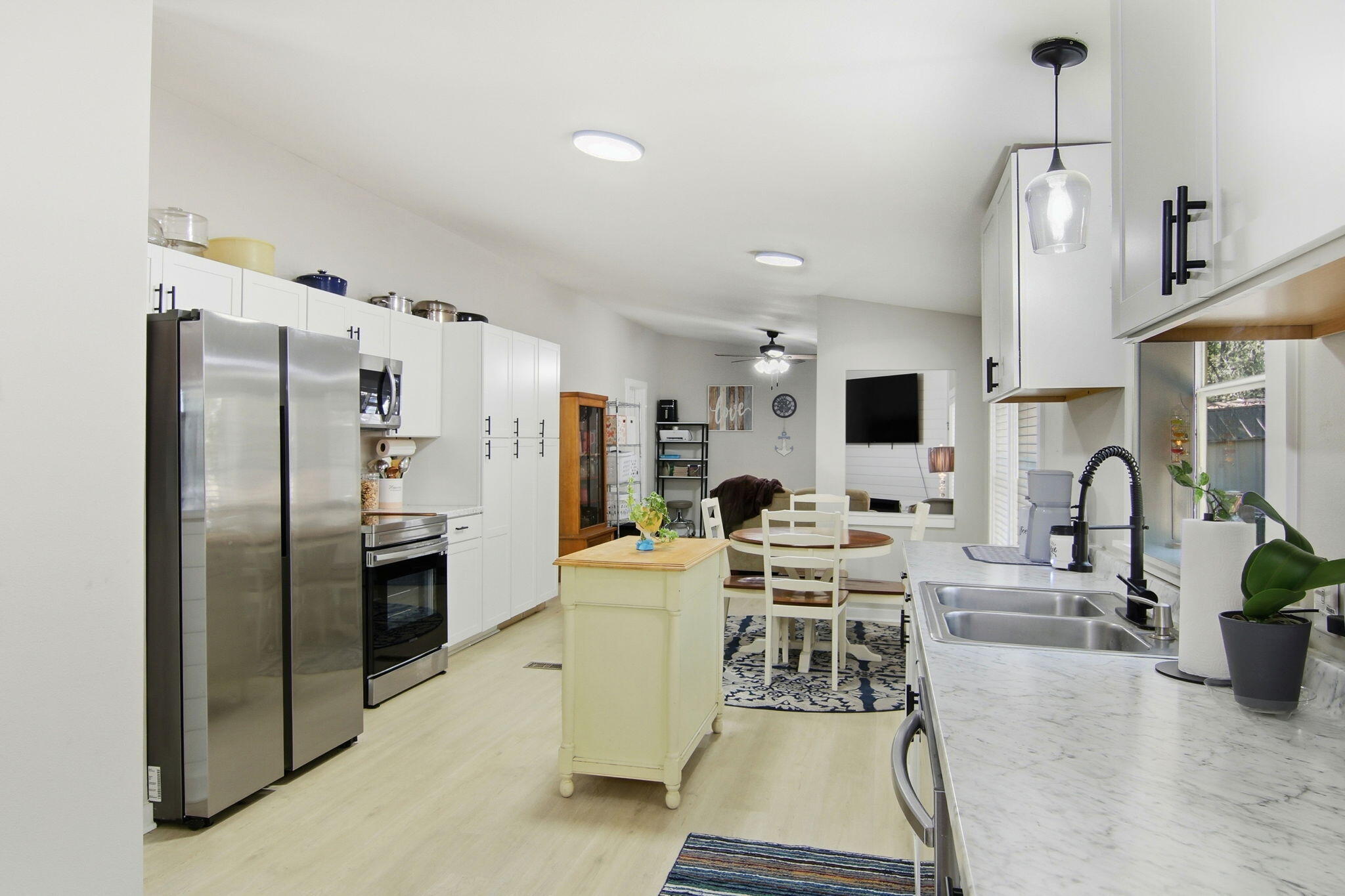 6108 Old River Road Baker, FL 32531 - Photo 17 of 40 a kitchen with stainless steel appliances kitchen island granite countertop a refrigerator a stove a microwave oven a sink with a dining table and chairs