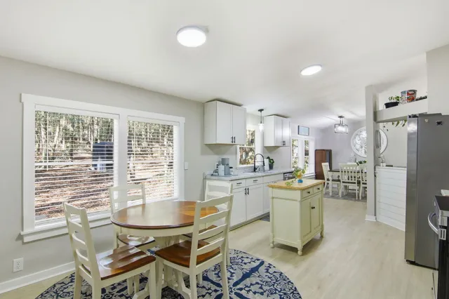a kitchen with stainless steel appliances kitchen island granite countertop a sink and a refrigerator