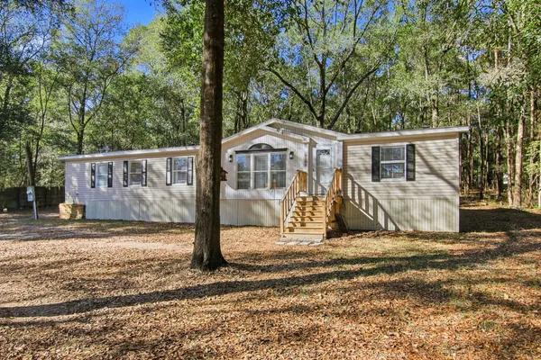 a front view of a house with a tree