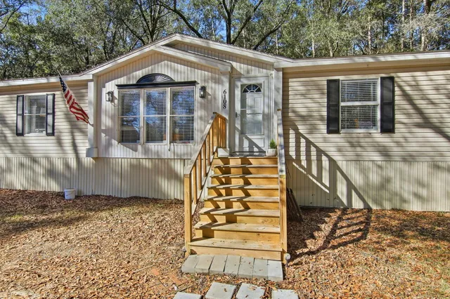 a view of a small house with roof deck front of house