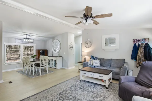 a living room with furniture a clock on wall and a window