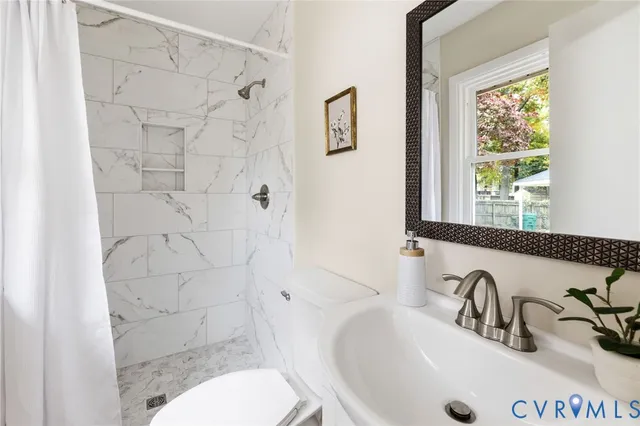 a bathroom with a sink a toilet and shower