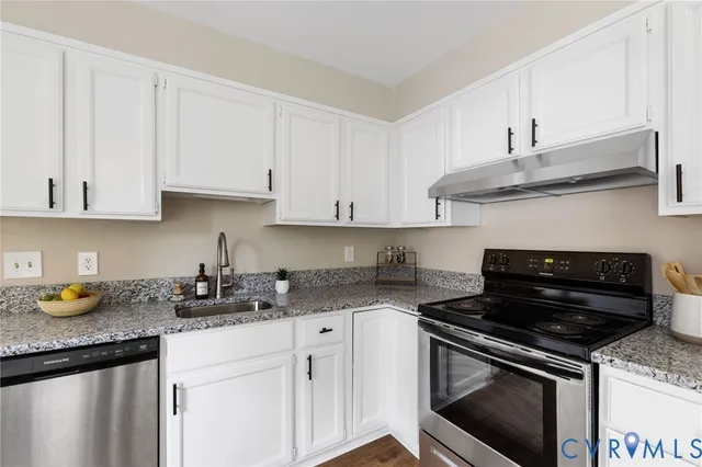a kitchen with granite countertop stainless steel appliances and white cabinets