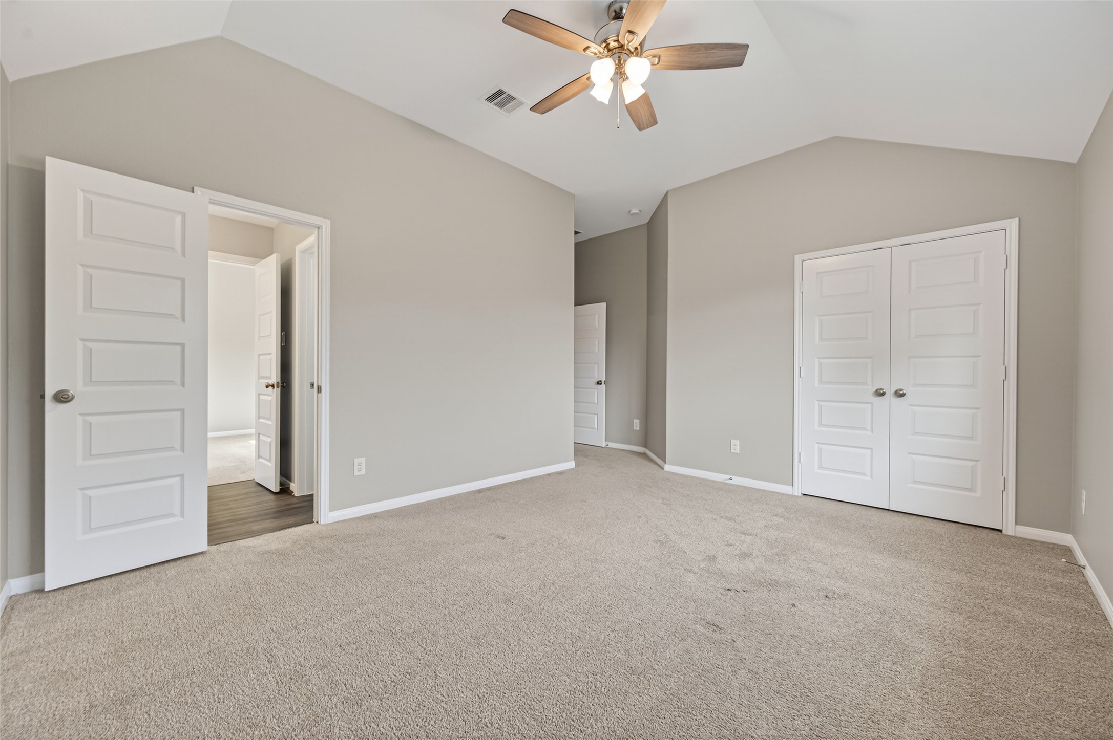 7003 Bristol Memorial Drive Spring, TX 77379 - Photo 37 of 40 Spacious secondary bedroom in this Spring TX 77379 home featuring vaulted ceilings, plush carpeting, and abundant natural light. The generous layout provides flexibility for a variety of furniture configurations, while the walk-in closet adds valuable storage. Direct access to the Jack-and-Jill bathroom enhances functionality and convenience. Located on the upper level, this well-sized bedroom complements the smart, multi-bedroom floorplan in this move-in ready home