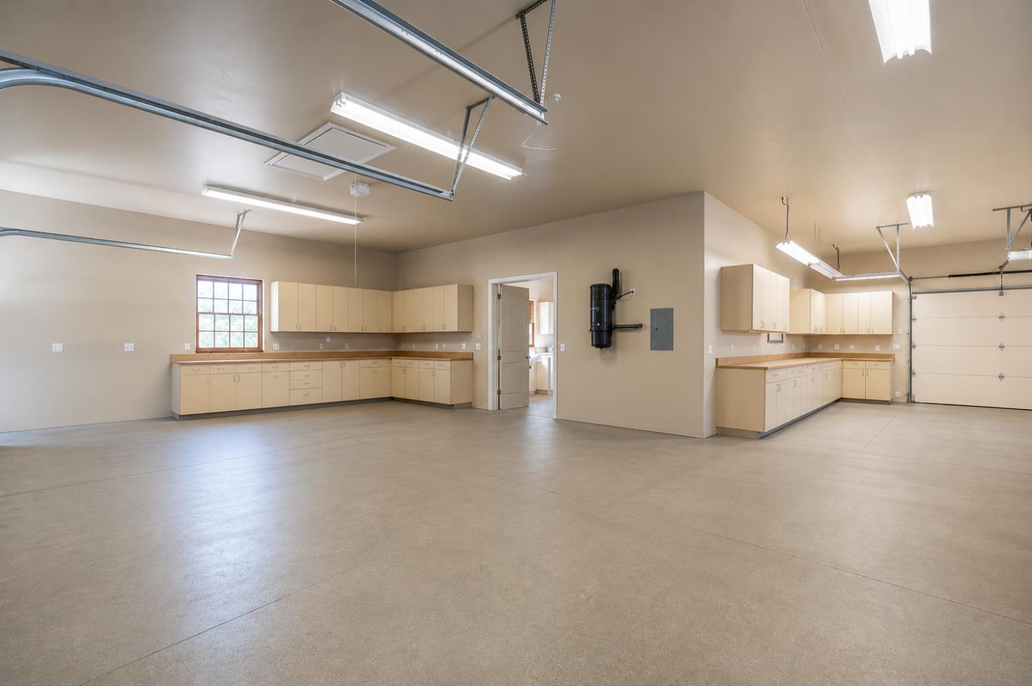 1100 Cold Springs Road Placerville, CA 95667 - Photo 52 of 97 Spacious garage featuring extensive built-in cabinetry, wood-finish countertops, durable concrete flooring, and multiple overhead light fixtures
