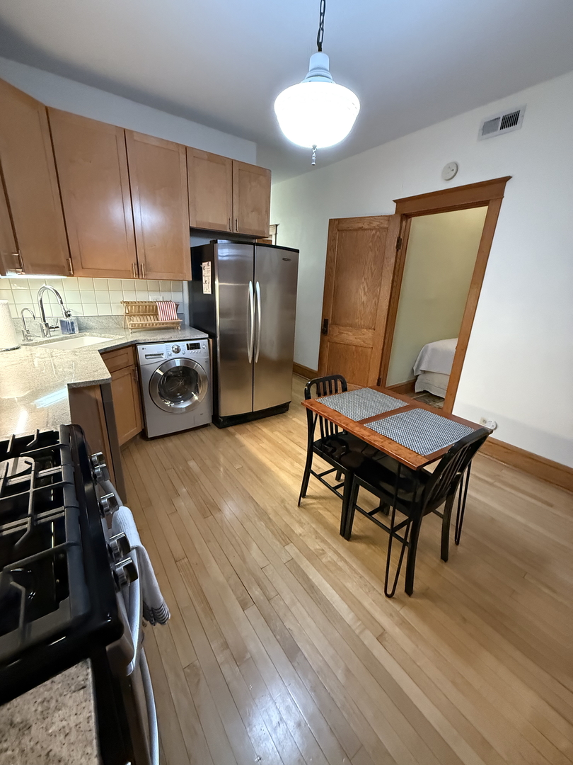 2134 North Damen Avenue, Unit 2 Chicago, IL 60647 - Photo 11 of 22 a kitchen with stainless steel appliances wooden floor and a stove top oven