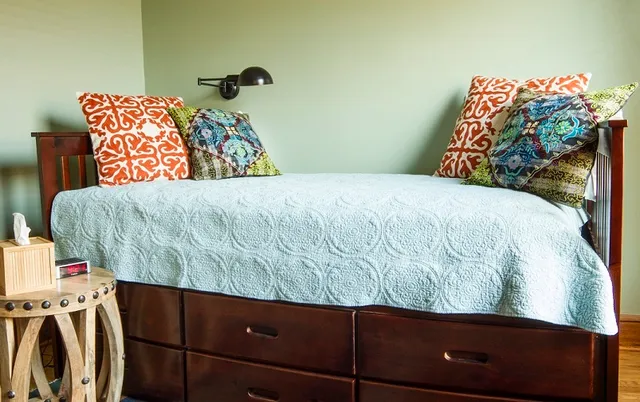a bedroom with a bed and a painting on the wall